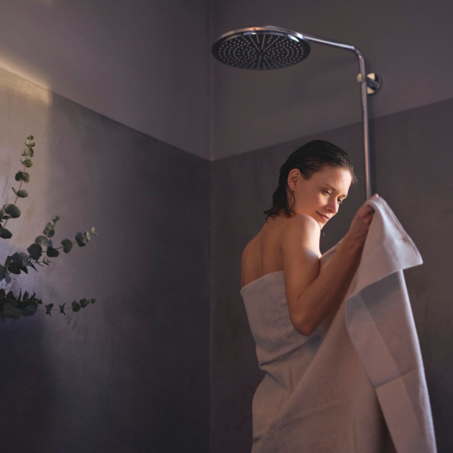 Vrouw onder de douche met baddoek om haar heen geslagen